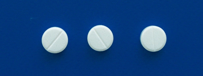 Three pills on a blue background.
